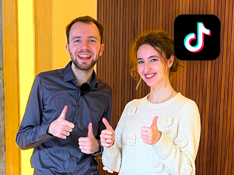 Maximilian Janisch with a student. Both show thumbs up with both hands.